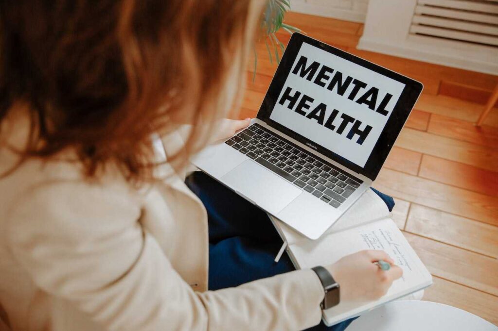 Salud mental, entrevista Tamara Otzen, ADN Radio. Imagen de una persona con un computador que dice "Mental health".